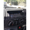 Car dashboard with radio and climate control knobs, showing a digital display.